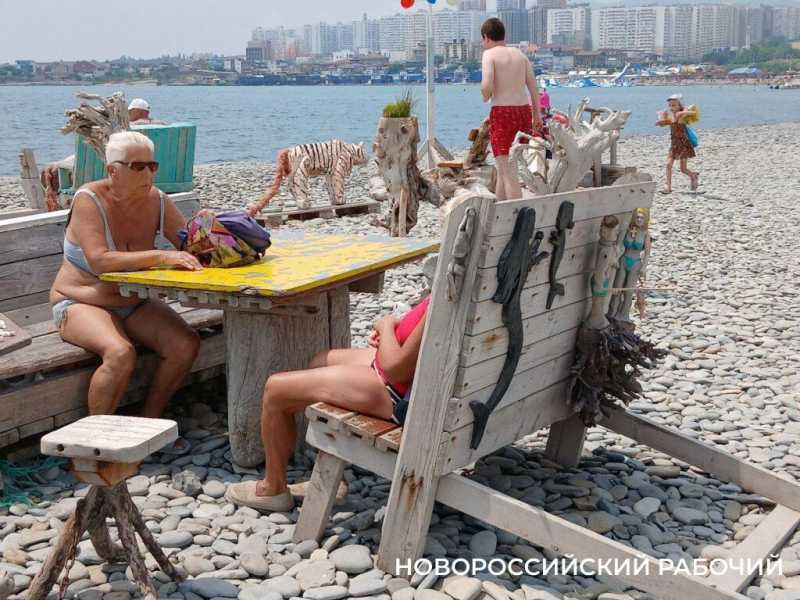 На пляже Новороссийска разглядывают наивные сцены из жизни «деревянных» отдыхающих